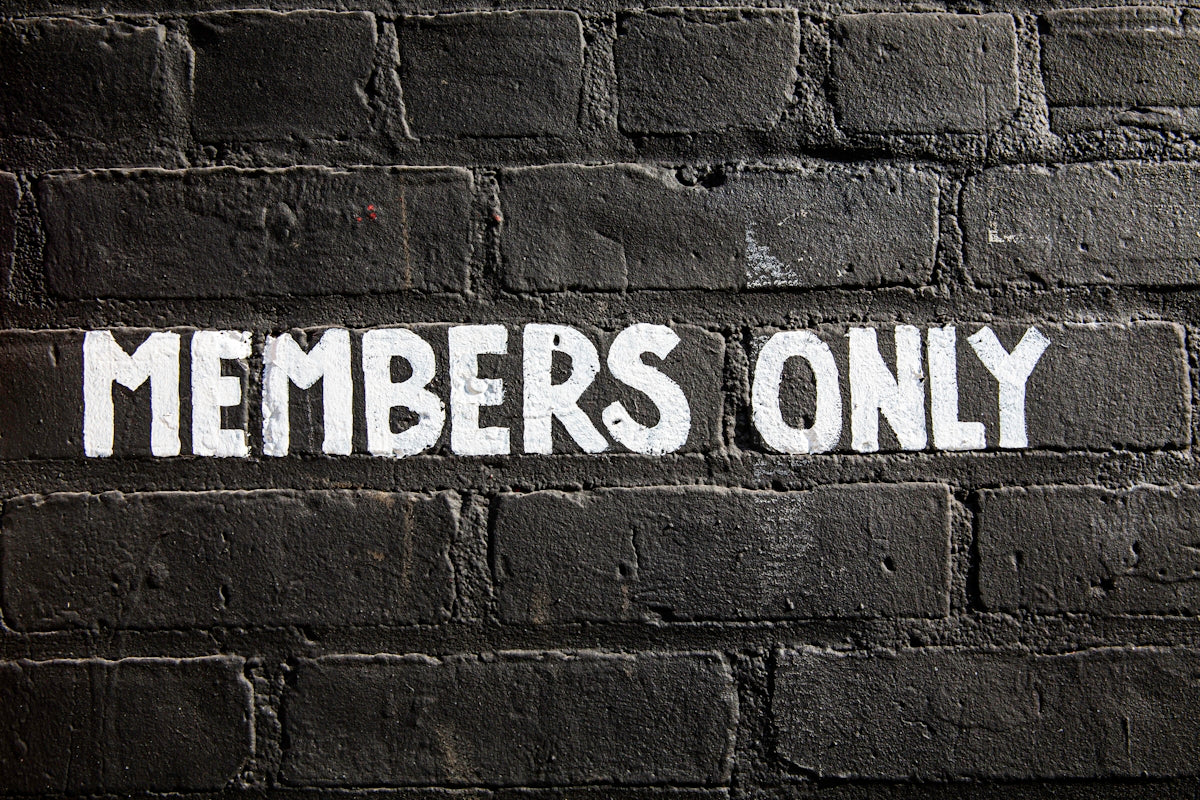 Members only sign on a brick wall